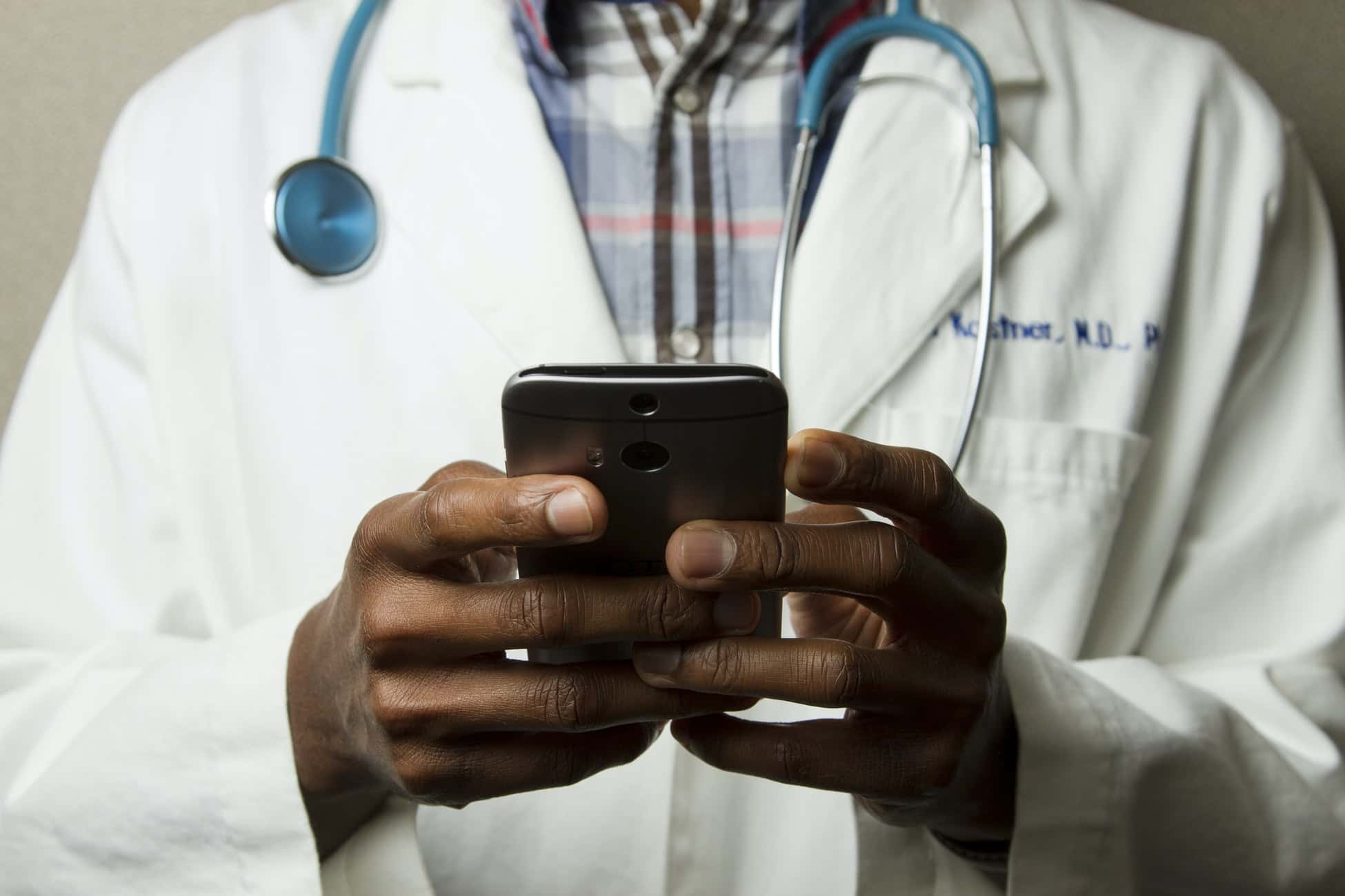 Doktor hasta onaylarını yönetmek ve belgeleri elektronik olarak imzalamak için akıllı telefonunu kullanıyor